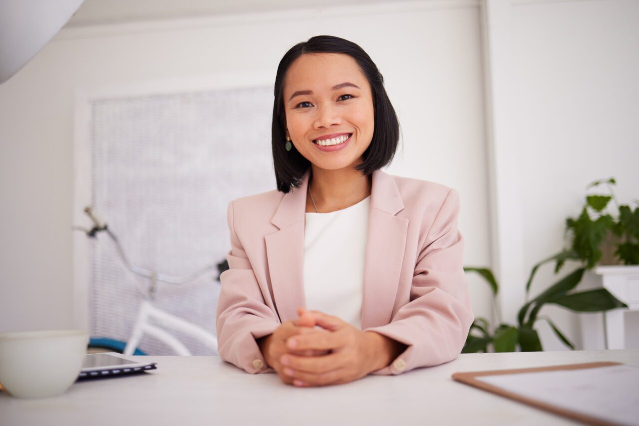Business woman, asian and boss or ceo of a company at office desk with a smile and pride for career